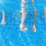 Feet Dipped into Swimming Pool